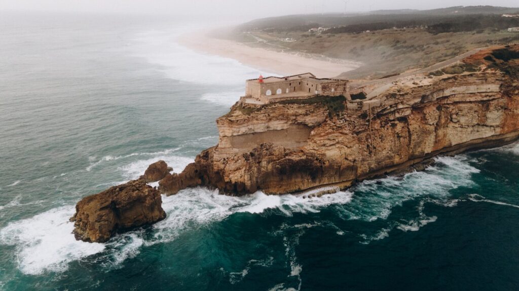 Mudar para a Costa de Prata de Portugal: O Guia Completo para Americanos 4 Vista aérea de uma falésia com uma casa no seu topo